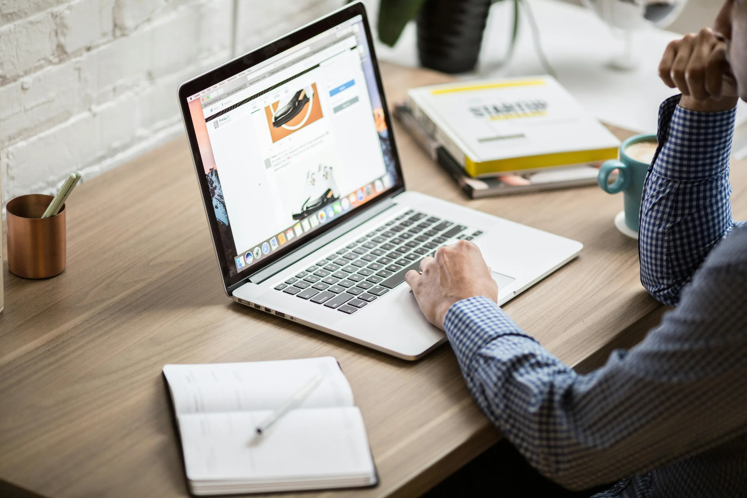 Person arbeitet an einem Laptop mit Notizbuch – 5 wesentliche SEO-Trends für Unternehmen im Jahr 2022